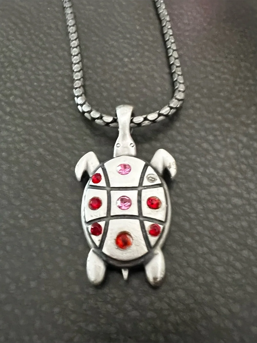 Silver tone Turtle Pendant Necklace with Red and Pink Accent Stones.